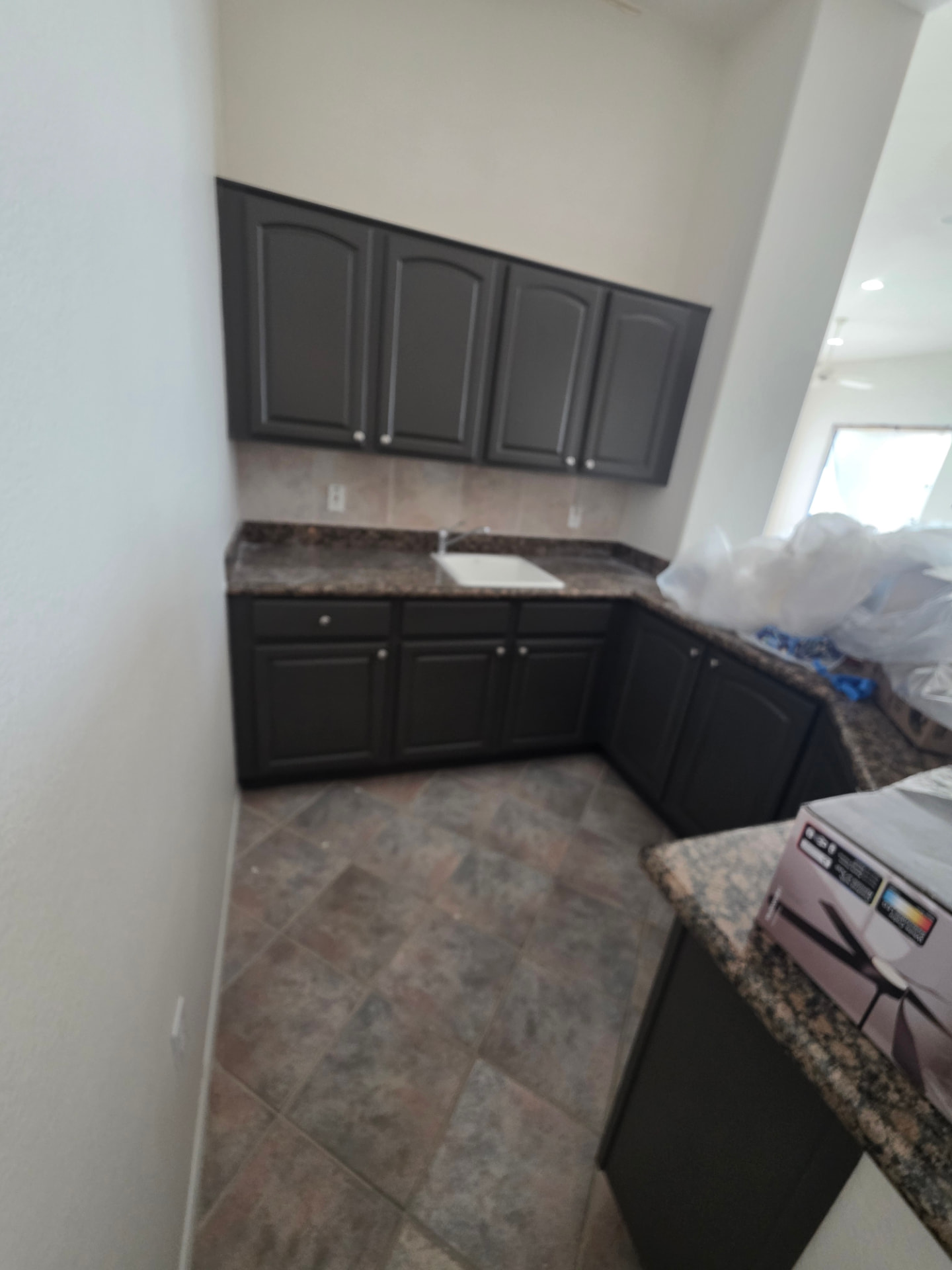 Painted dark upper and lower cabinets in a kitchen nook