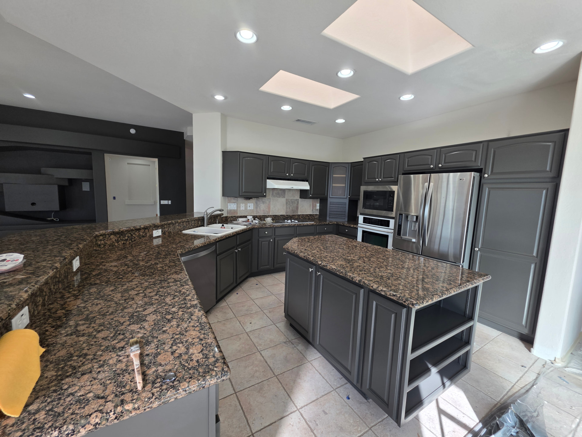 Kitchen cabinets freshly painted dark charcoal with granite counters